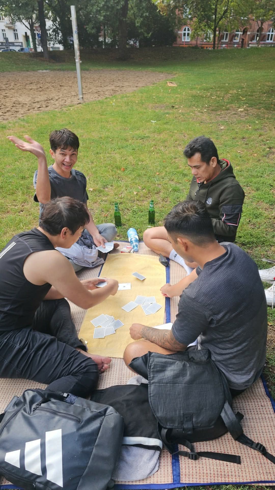 Friends playing cards together in a park in Hamburg