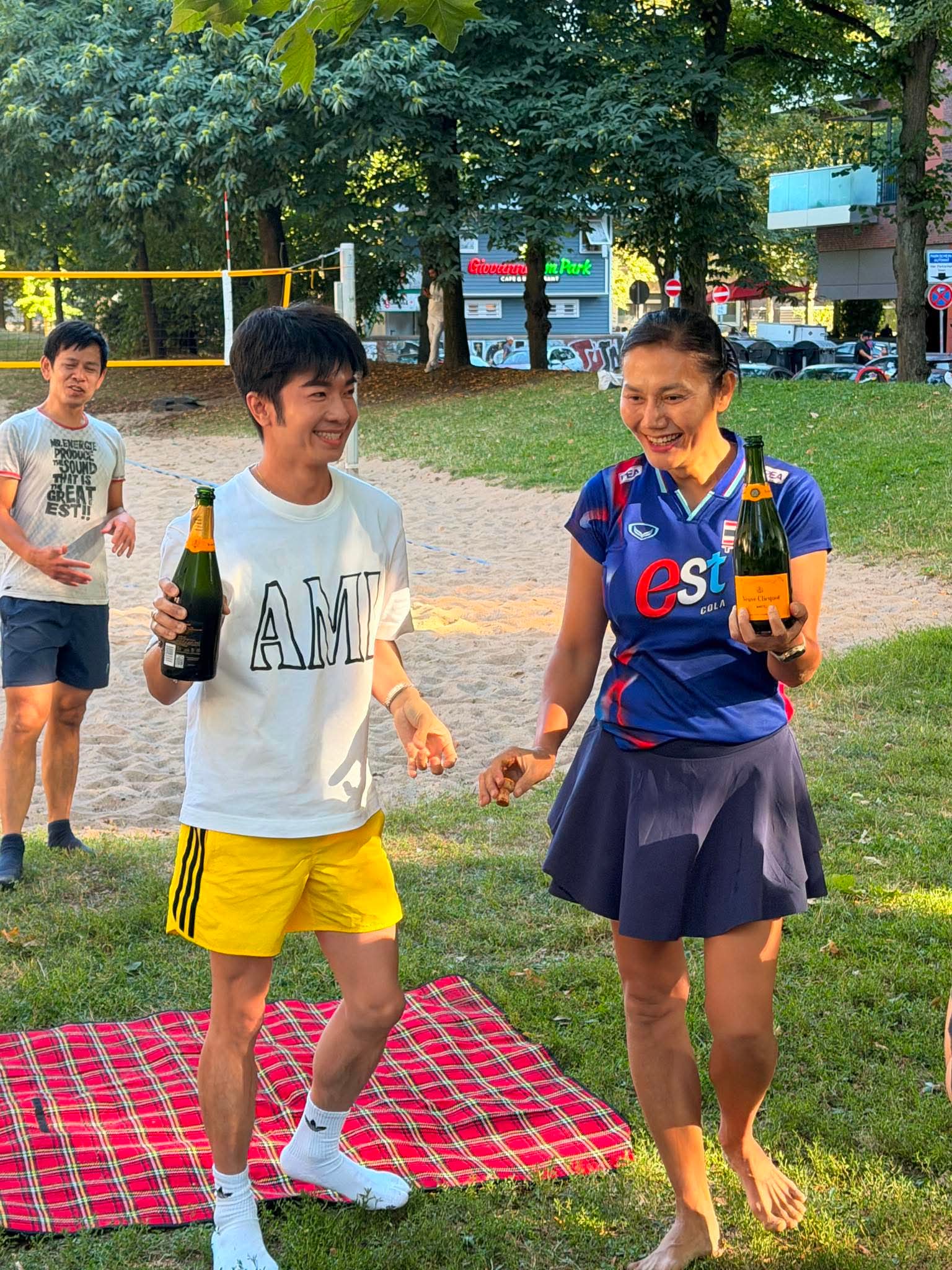 Friends celebrating outdoors with bottles in a Hamburg park
